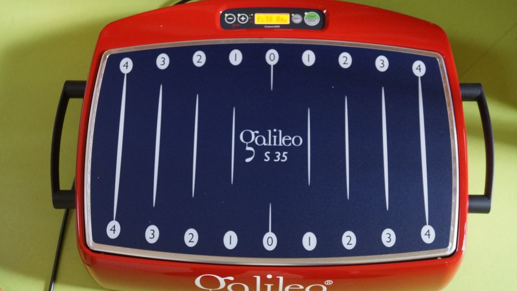 Rotes Therapiegerät Galileo auf grünem Fußboden